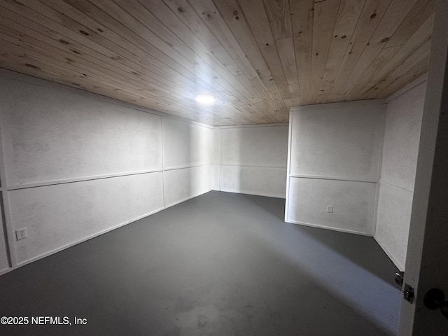 spare room with wood ceiling and finished concrete floors