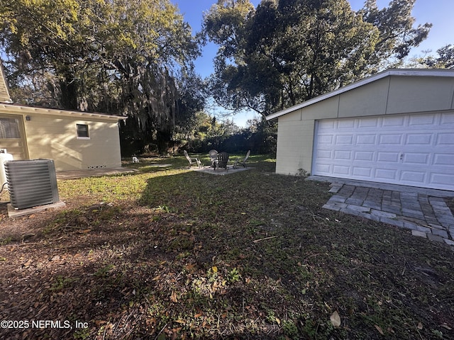 view of yard with central AC unit, an outdoor structure, and a garage