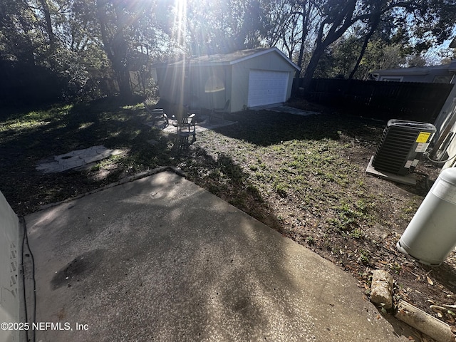 view of yard with a detached garage, an outdoor structure, and fence