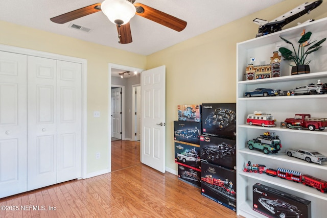 interior space with visible vents, wood finished floors, and a ceiling fan