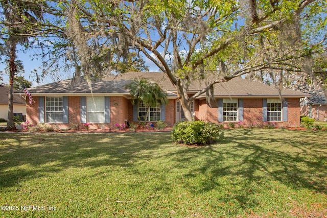 ranch-style home featuring brick siding and a front lawn