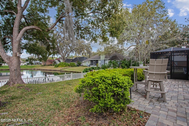 view of yard with a patio area, a water view, and fence