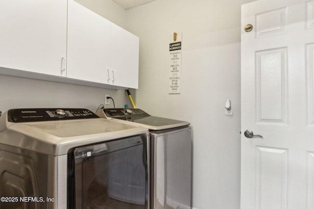 clothes washing area with washing machine and clothes dryer and cabinet space