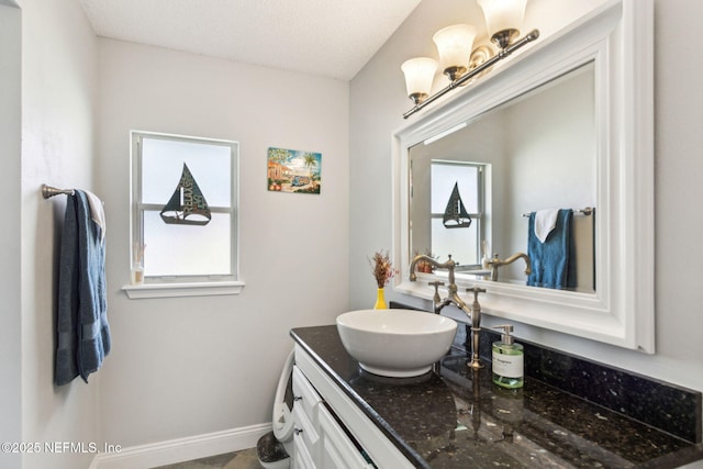 bathroom featuring vanity, plenty of natural light, and baseboards