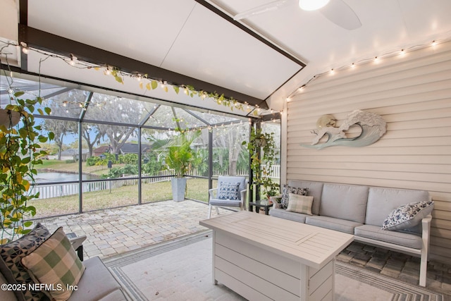 sunroom featuring a wealth of natural light, a water view, and ceiling fan