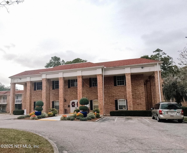 view of building exterior with uncovered parking