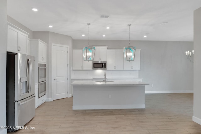 kitchen with a sink, visible vents, appliances with stainless steel finishes, and white cabinets