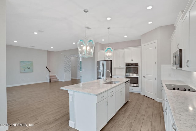 kitchen featuring a sink, decorative backsplash, appliances with stainless steel finishes, and wood tiled floor