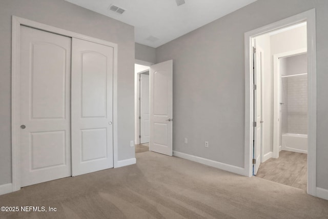 unfurnished bedroom featuring a closet, visible vents, baseboards, and carpet