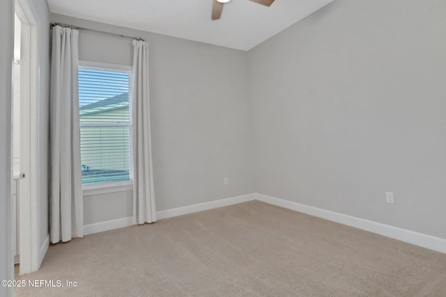 spare room featuring light colored carpet, baseboards, and a healthy amount of sunlight