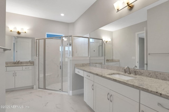 bathroom with a shower stall, two vanities, marble finish floor, and a sink