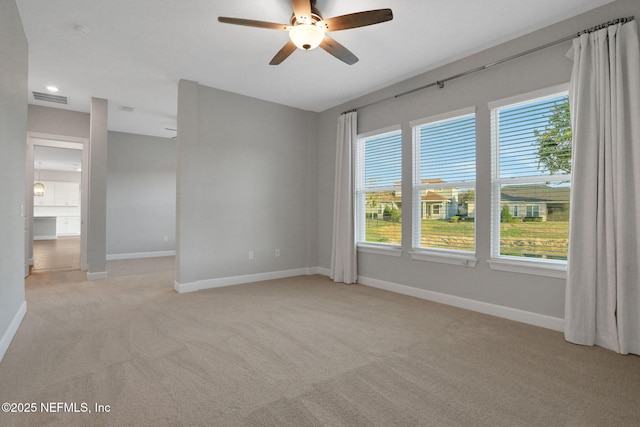 empty room with baseboards, light carpet, and ceiling fan