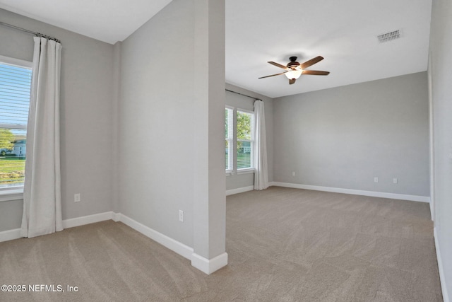 empty room with visible vents, light carpet, and baseboards