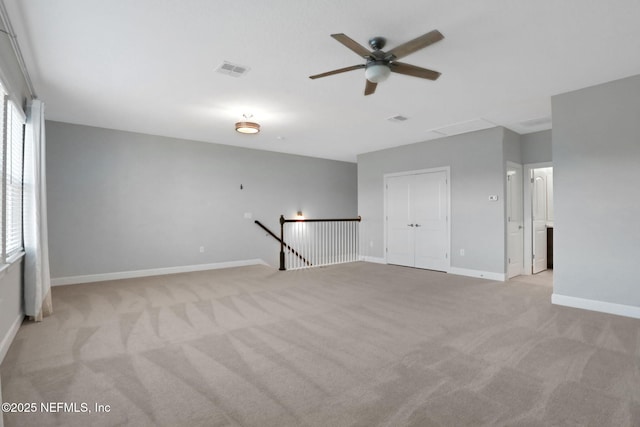 spare room with light colored carpet, visible vents, and baseboards