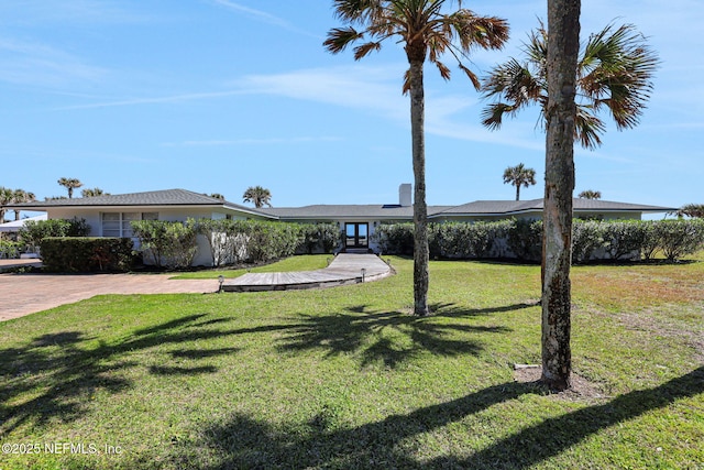 view of front facade with french doors and a front lawn