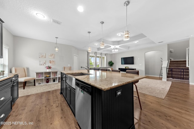 kitchen with stainless steel dishwasher, light wood-style flooring, arched walkways, and a sink