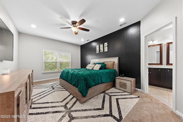 bedroom featuring baseboards, visible vents, ensuite bath, recessed lighting, and light carpet