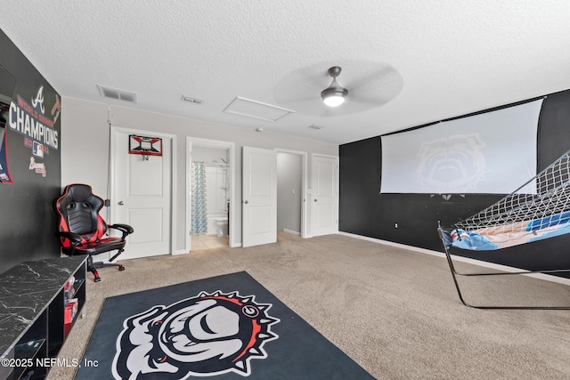 playroom featuring visible vents, carpet floors, a textured ceiling, and attic access