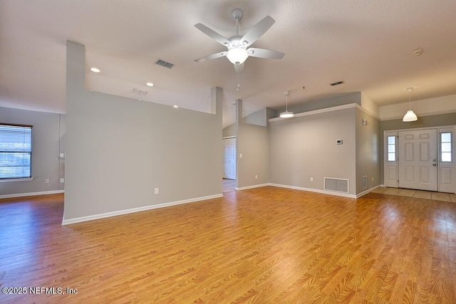 unfurnished living room featuring visible vents, baseboards, and light wood finished floors