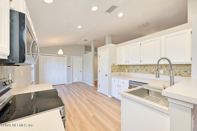 kitchen featuring visible vents, stainless steel appliances, white cabinets, light countertops, and lofted ceiling