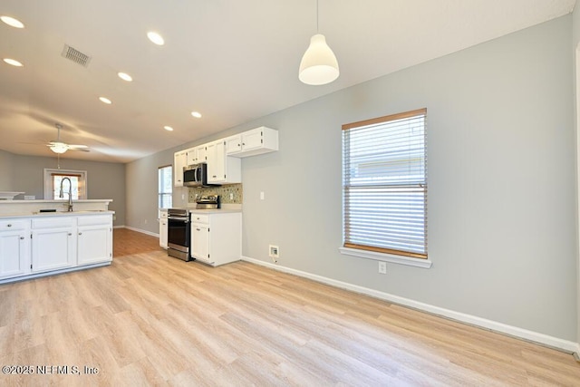 kitchen with stainless steel appliances, plenty of natural light, tasteful backsplash, and light wood-style flooring