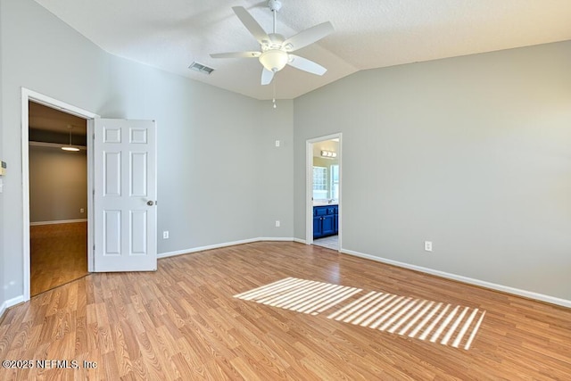 unfurnished room with visible vents, lofted ceiling, baseboards, and light wood finished floors