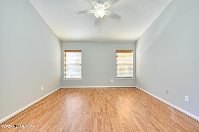 unfurnished room with plenty of natural light, light wood-type flooring, and a textured ceiling