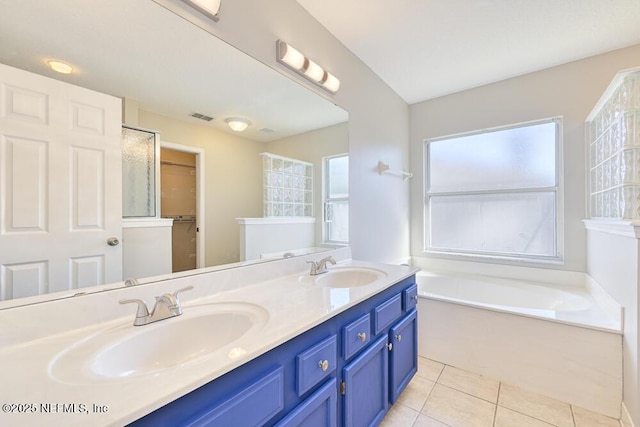 bathroom featuring a sink, a garden tub, double vanity, and tile patterned floors