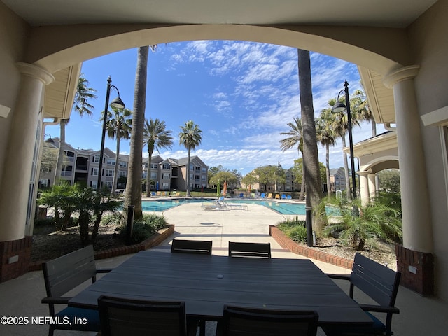 view of patio with outdoor dining space, a residential view, and a community pool