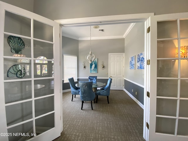 dining space with visible vents, crown molding, baseboards, an inviting chandelier, and dark colored carpet