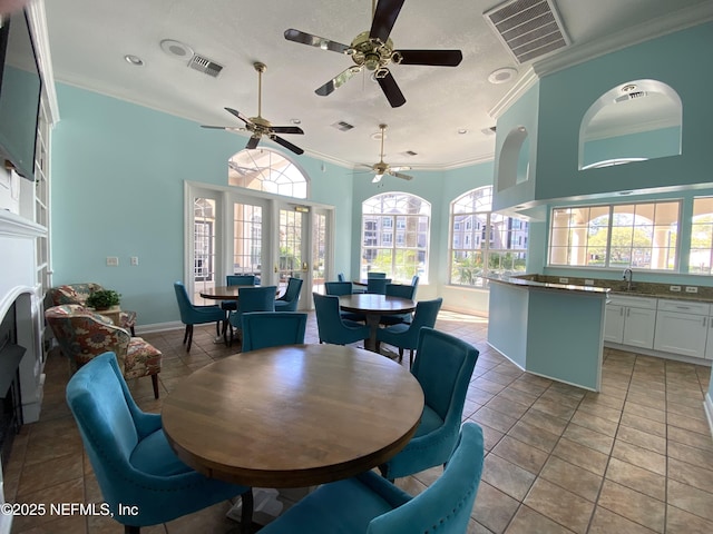 dining room with light tile patterned floors, visible vents, and ornamental molding