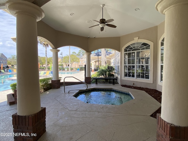 community pool with ceiling fan, a patio, and a hot tub