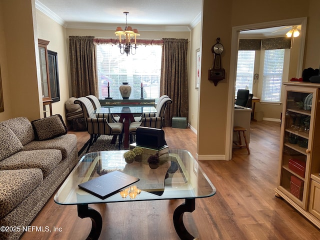 living area featuring light wood-type flooring, baseboards, an inviting chandelier, and crown molding