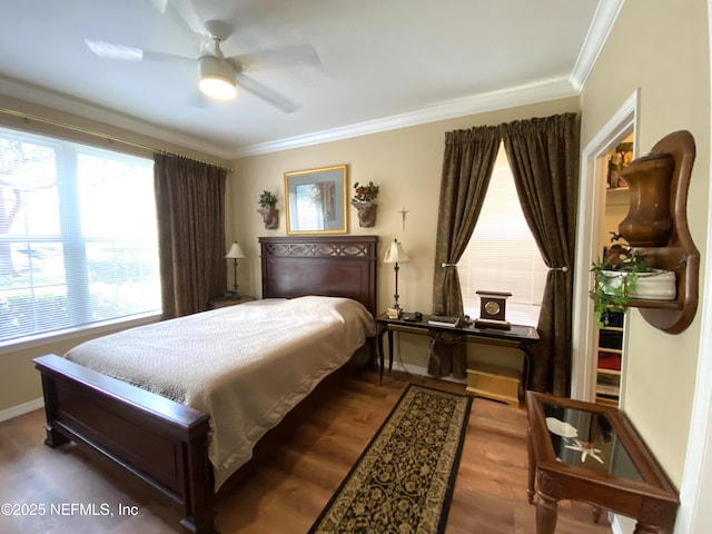 bedroom featuring ceiling fan, baseboards, wood finished floors, and crown molding