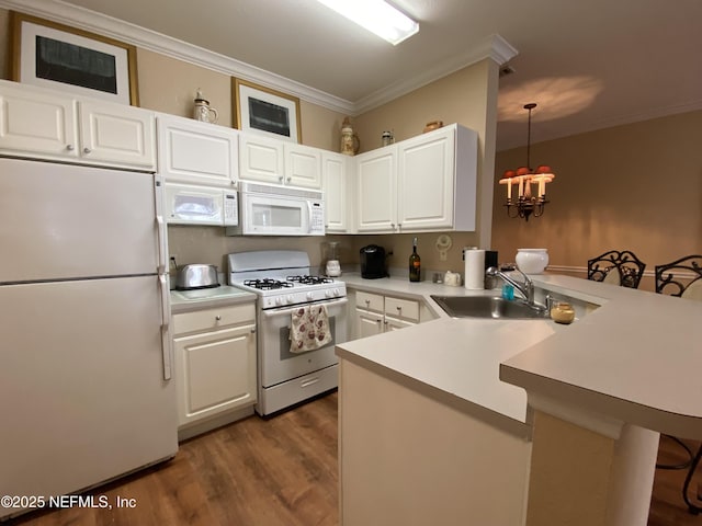 kitchen with a breakfast bar, ornamental molding, a sink, white appliances, and a peninsula