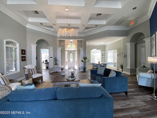 living area featuring dark wood-type flooring, a notable chandelier, arched walkways, a high ceiling, and ornate columns