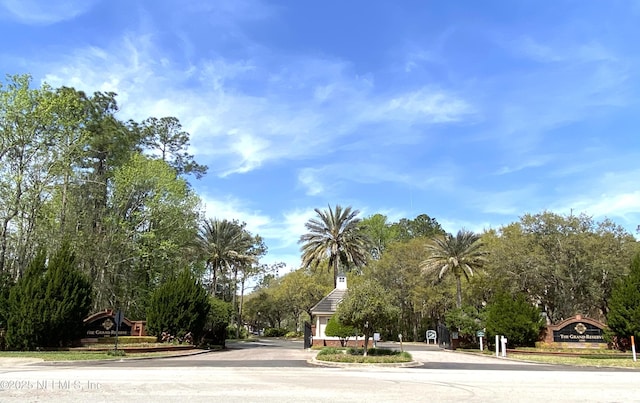 view of street featuring a gated entry and curbs