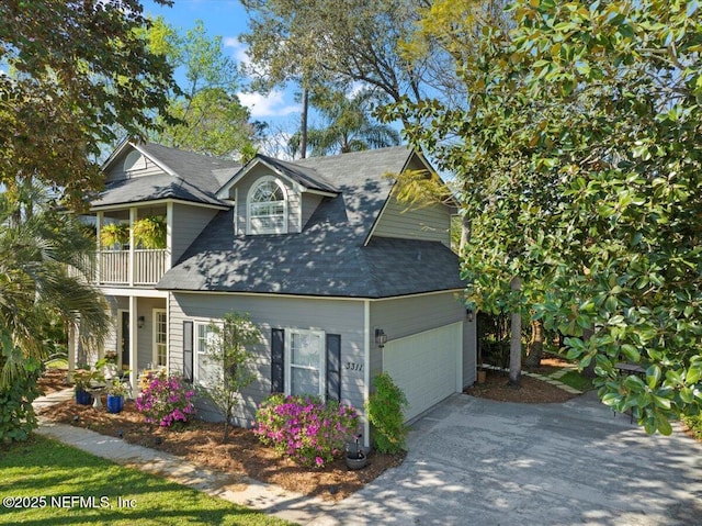 view of side of home featuring a balcony, roof with shingles, concrete driveway, and an attached garage