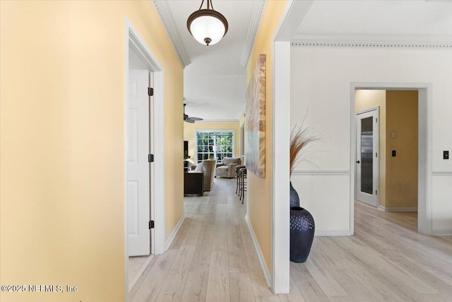 corridor featuring crown molding, baseboards, and wood finished floors