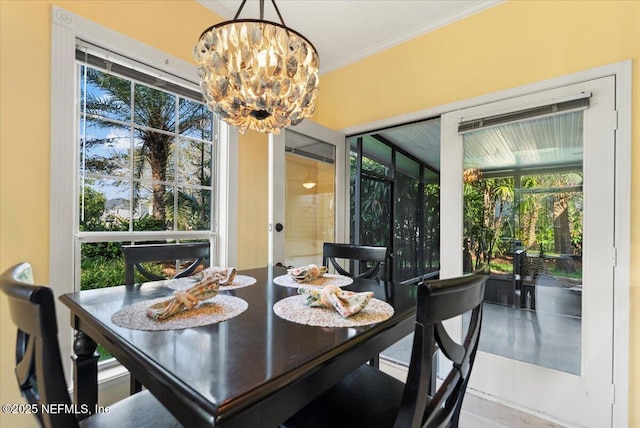 dining space with crown molding and a notable chandelier