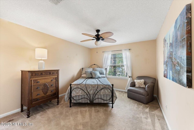 carpeted bedroom with ceiling fan, baseboards, and a textured ceiling