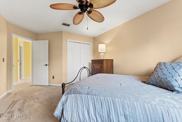 carpeted bedroom featuring visible vents, a ceiling fan, a textured ceiling, a closet, and baseboards