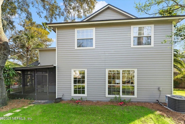 rear view of house with cooling unit, a yard, and a sunroom