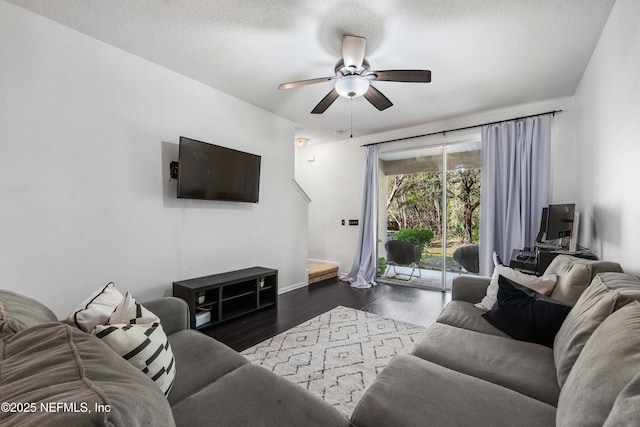 living area featuring a ceiling fan, wood finished floors, baseboards, and a textured ceiling