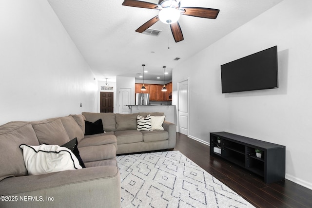 living area with dark wood-style floors, visible vents, baseboards, and a ceiling fan