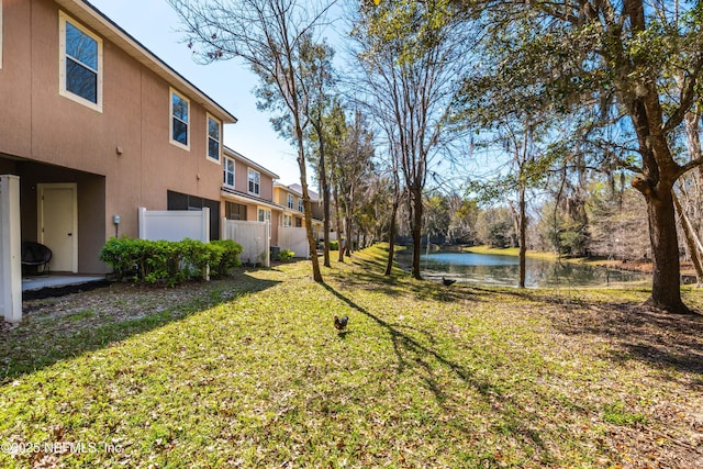 view of yard featuring fence and a water view