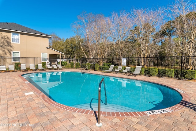 pool featuring fence and a patio area