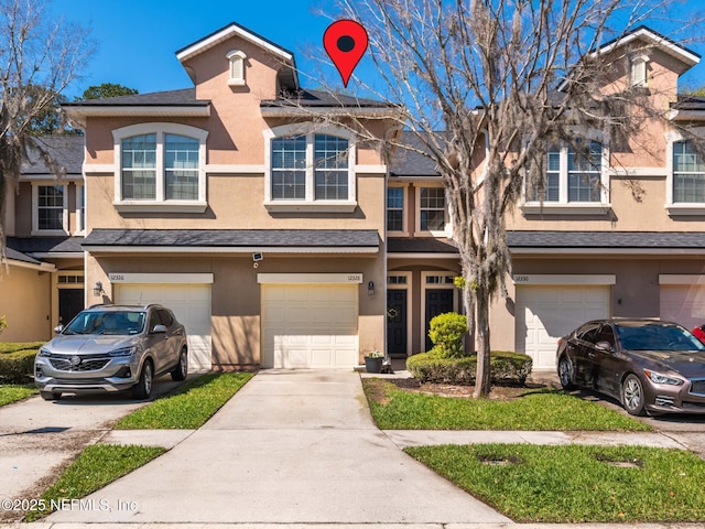 multi unit property featuring a shingled roof, an attached garage, driveway, and stucco siding