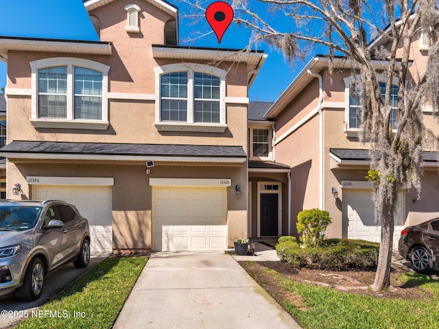 multi unit property with a shingled roof, a garage, driveway, and stucco siding