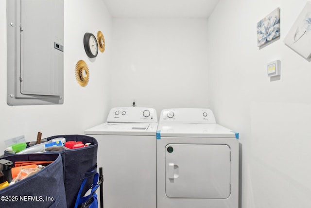 clothes washing area with electric panel, laundry area, and washer and dryer